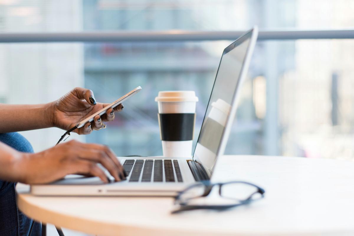 A professional office setting with a person using a computer, organizing files, and communicating with colleagues.