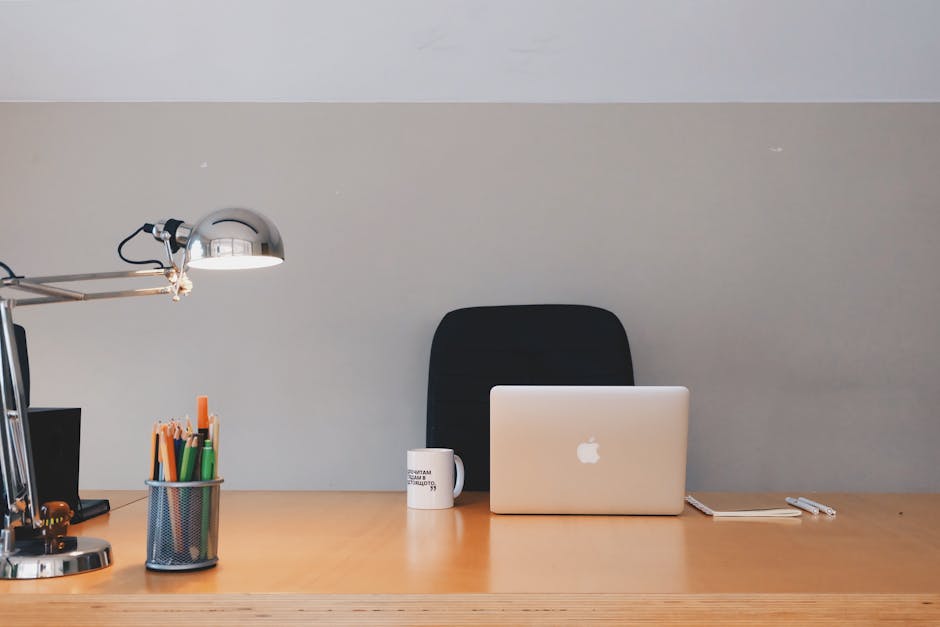 A cozy and well-organized home office workspace with a desk, computer, and other necessary equipment.