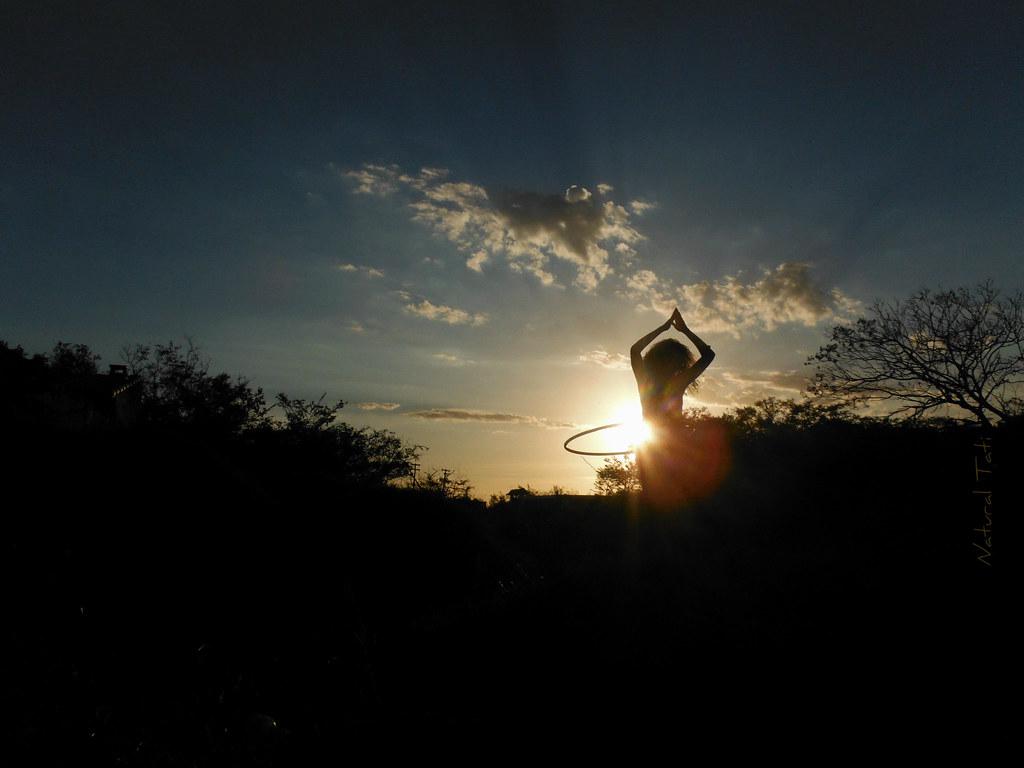 A person looking calm and relaxed while practicing yoga or stretching outdoors in nature.