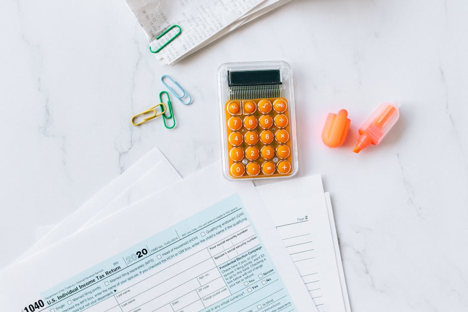 A close-up view of a calculator and various financial documents related to income tax calculations for property owners.