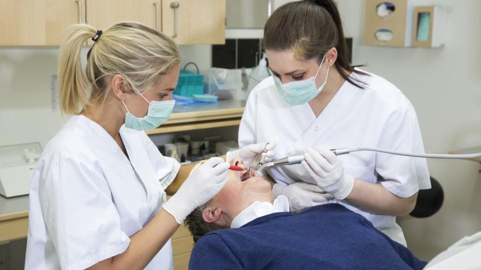 An NHS dentist provides essential dental treatments such as examinations, fillings, and extractions to a patient.