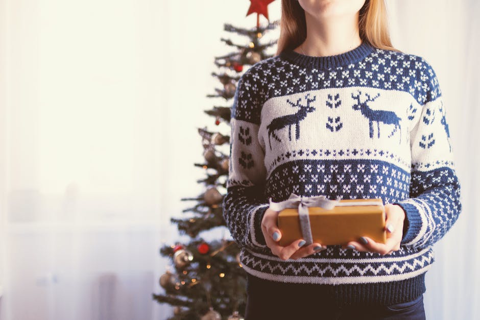 A close-up of a person holding a subscription box with different products inside.